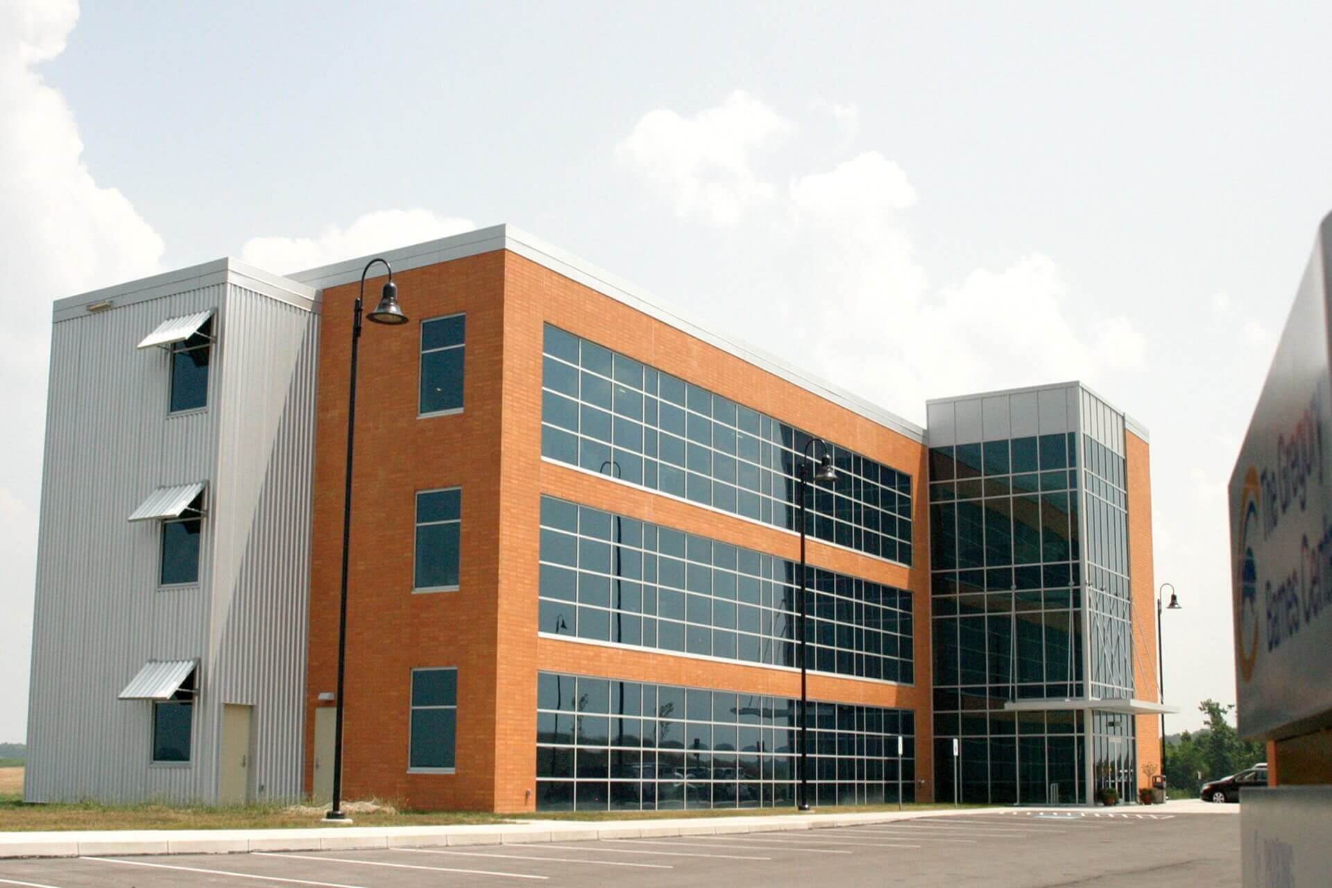 A modern brick and glass office building under a cloudy sky.