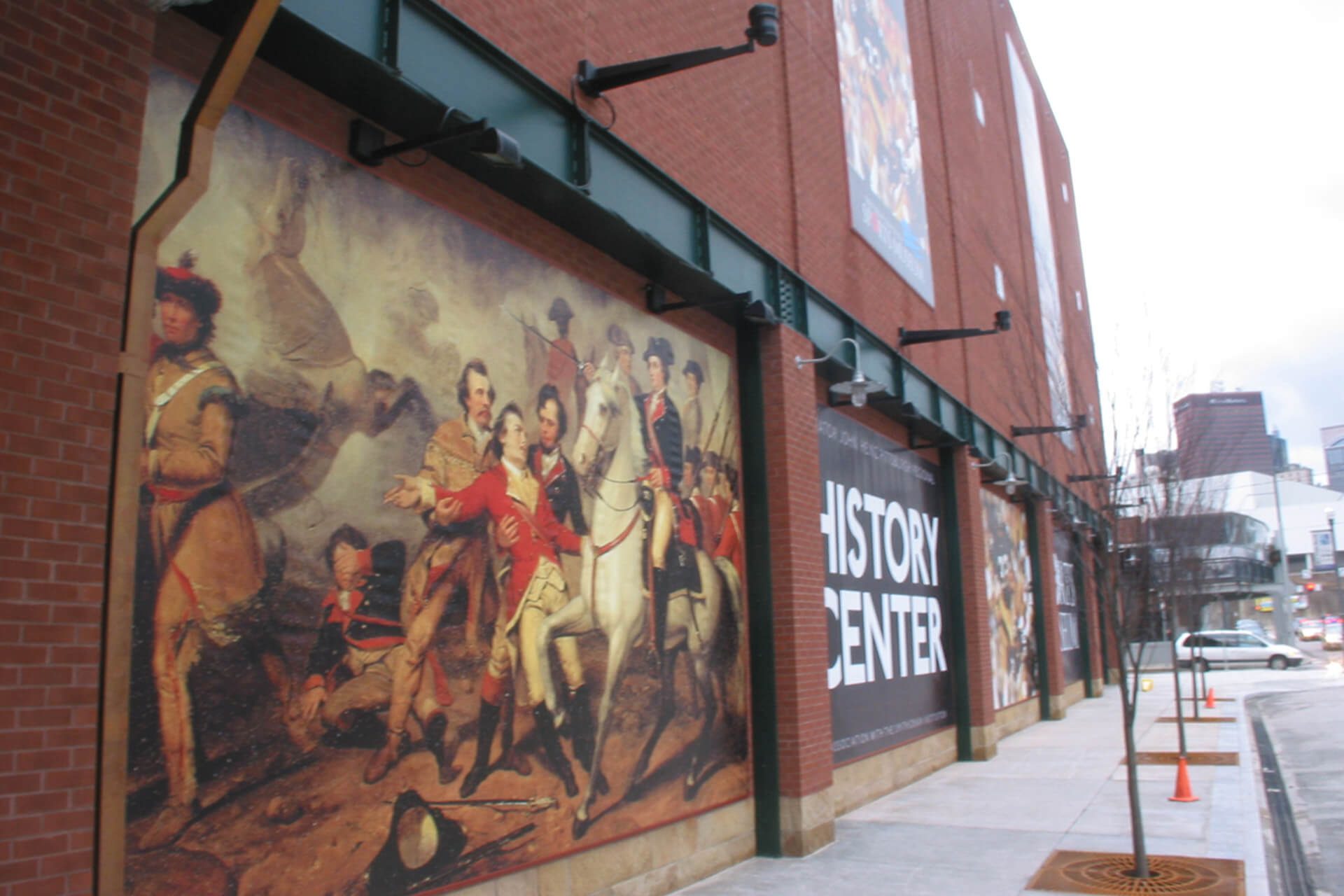 Large historical mural on a red brick building exterior.
