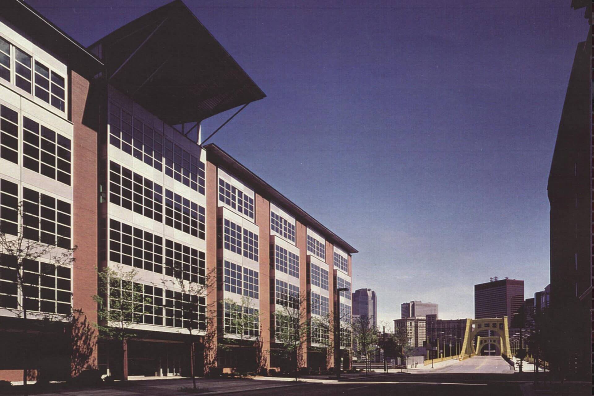 Modern multi-story building with large windows under a clear sky.