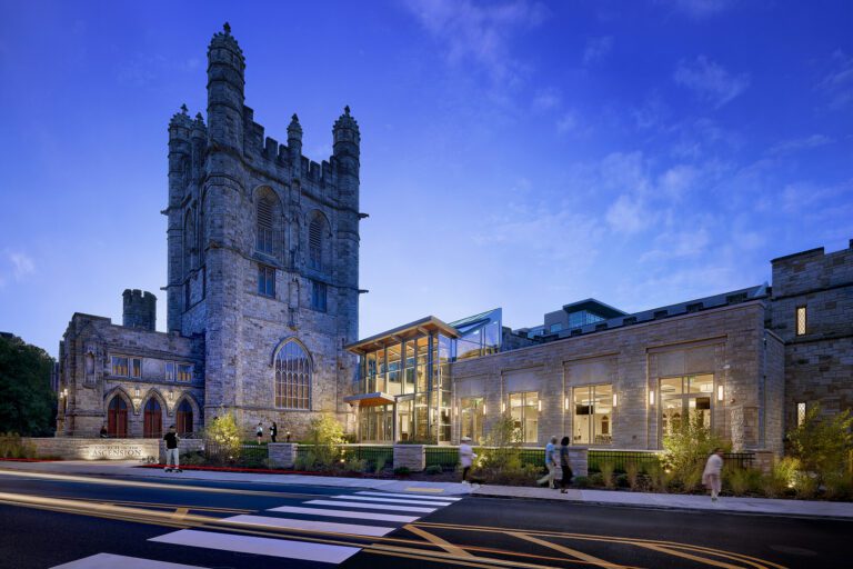Historic stone building with modern extension, evening.