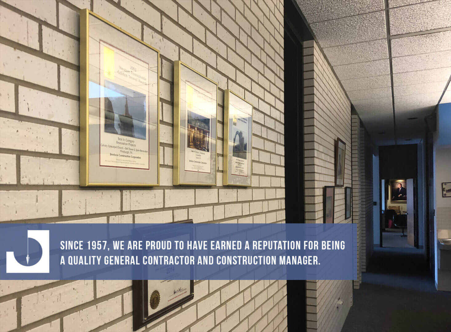 Brick-walled office corridor with framed certificates